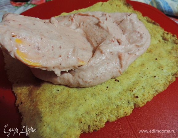 Приступаем к сборке. Первым выкладываем песочный корж. Щедро смазываем клубничным кремом, примерно третьей частью.