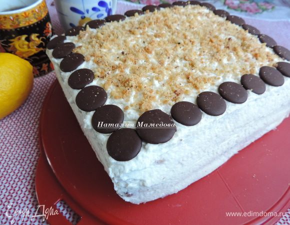 Обмазываем торт взбитыми сливкам, украшаем по желанию. У меня шоколадные диски и крошка от песочного коржа. Украшала на скорую руку, так как везла торт в гости к маме. Долгую дорогу украшения все равно бы не пережил!