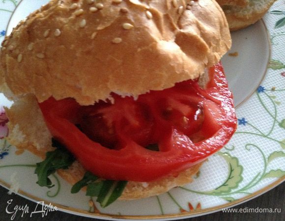 Булочки разрезать, положить ч/л сливочного соуса или майонеза, руколу, дольку помидора (у меня очень большой помидор).