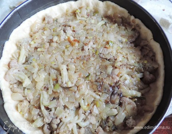 Достаем из холодильника тесто. Руками распределяем по форме для выпекания. У меня круглая диаметром 23 см. Дно формы я выстилаю бумагой, чтоб пирог было легче достать, бока ничем не смазываю. Не забываем про бортики, лучше их сделать повыше. Часто накалываем тесто вилкой и выкладываем начинку.