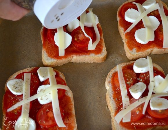 Положите несолько полосочек сыра эмменталь, присыпьте тертым пармезаном и (по желанию) сухой орегано. 