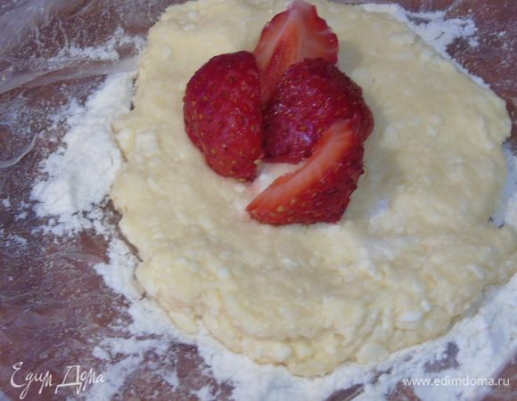 Творожное тесто разделить на 6-8 частей, каждую часть размять в лепешечку, в середину положить нарезанную клубнику.
