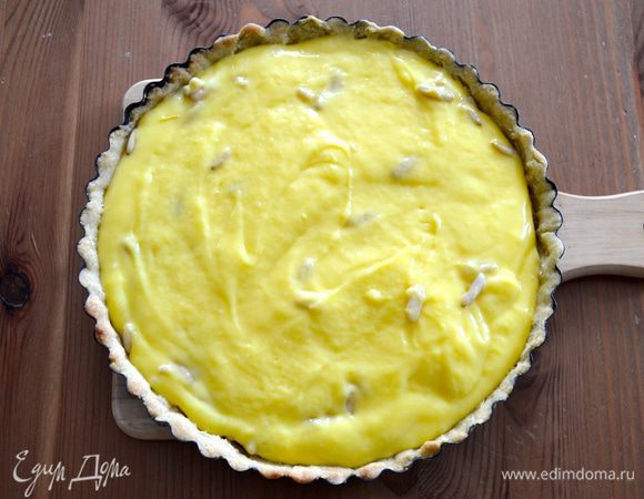 В остывший крем добавьте кедровые орешки (в рецепте оригинале используем орешки пинии), оставьте буквально столовую ложку орехов для украшения поверхности торта. Перемешайте орешки с кремом и выложите его в подготовленное основание тарта.