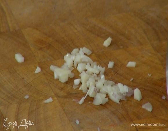 Чеснок почистить, мелко порезать и отправить к луку.