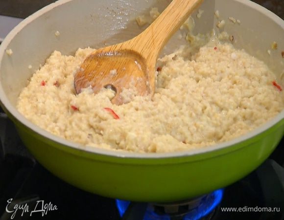 Горячую пшеничку выложить в сковороду с соусом, вернуть на плиту, перемешать, влить оставшееся вино и прогреть все на медленном огне.