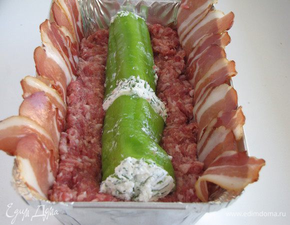 Выложить половину фарша. Сверху положить фаршированный перец, немного вдавливая его в фарш.