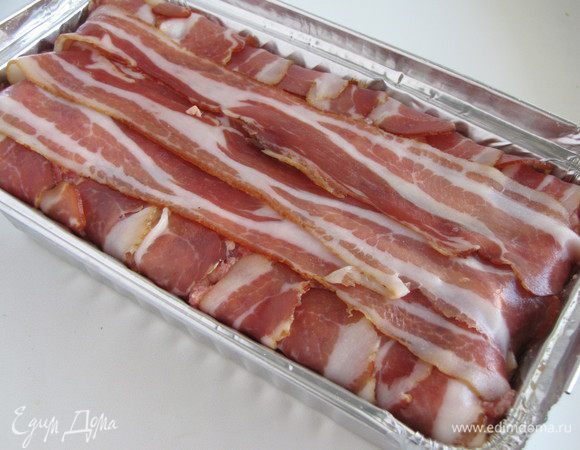 Выложить сверху оставшийся фарш, прижать руками и закрыть полосками бекона.