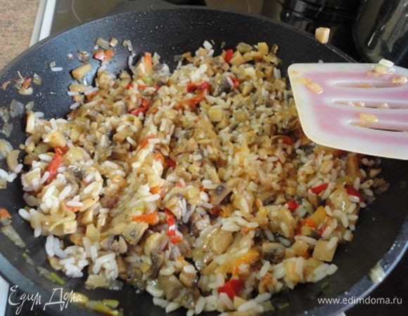 В сковороде разогреть 3 ст. ложки растительного масла и обжарить лук до золотистого цвета (3 мин.). Потом добавить сладкий перец и еще жарить 5 минут. Добавить грибы и тушить под крышкой минут 10. Готовые овощи смешать с рисом, добавить соль, специи - все по вкусу.