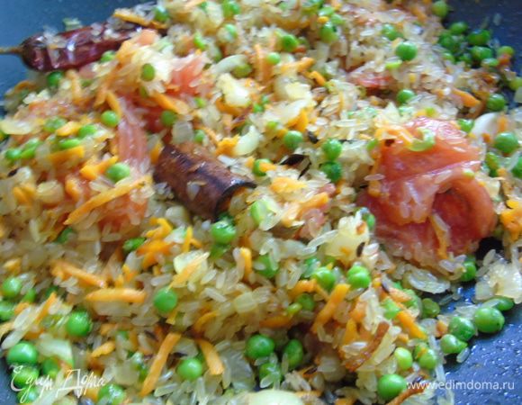 К овощам добавьте рис и сухую приправу для плова. Все тщательно перемешайте.