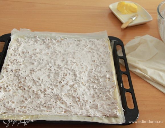 На лист теста равномерно выложить треть орехово-белковой массы. Затем 4, 5 и 6 листы фило, каждый раз смазывая тесто маслом. Затем второй слой начинки, 7 и 8 листы фило (не забываем про сливочное масло), третий слой начинки, 9, 10 и 11 слои теста. Последний, верхний слой фило маслом не смазываем.