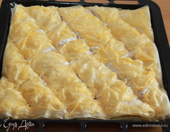 Верхний слой теста подвернуть по краям внутрь, смазать желтком. Аккуратно разрезать пирог на порционные куски, не прорезая до основания. Когда я готовила пахлаву первый раз, совершила такую глупость: сначала разрезала, а потом решила смазывать желтком. Было весело! Каждый отрезанный кусочек теста норовил приклеиться к кисточке.
Я готовила этот пирог много раз, поэтому есть фото с разными способами нарезки пахлавы: по диагонали, в виде ромбов, и квадратиками; и с разными орехами сверху: с грецкими и с фисташками. Количество порций тоже варьируется: у меня получалось от 33 до 48!