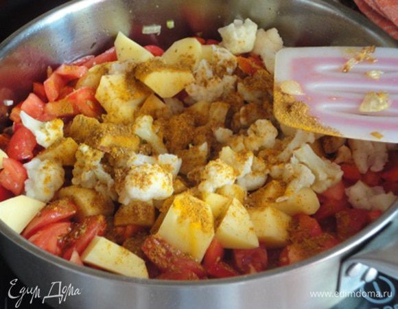 Теперь добавьте имбирь и перчик чили и, не увеличивая нагрев, помешивая, жарьте еще пару минут. Добавьте помидоры и болгарский перец, перемешайте. Через полминуты эти овощи дадут сок, вот теперь можно добавить картофель, цветную капусту, специи. Все тщательно перемешайте и готовьте минуты три.