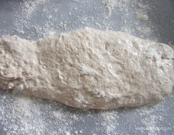 На противень расстелить пекарскую бумагу, посыпать сверху мукой. С помощью лопатки выложить тесто. Постарайтесь, чтобы верхний слой, присыпанный мукой, был сверху. С помощью ножа разделить тесто на 2 части, сформировать батончики. 