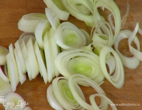 Светлую часть лука-порея нарезать тонкими кольцами.