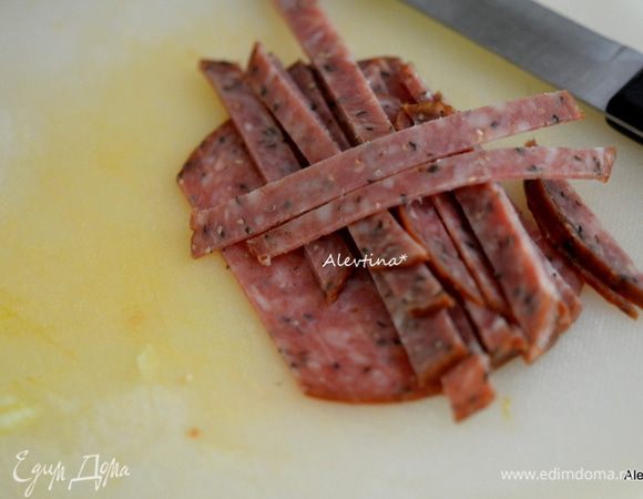 Салями порезать полосками. Приготовить заправку, смешав оливковое масло с соком 1 лимона.