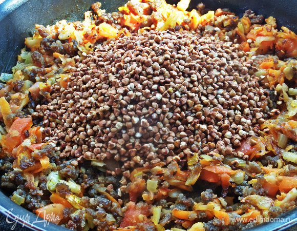 Высыпать прокалённую гречку.