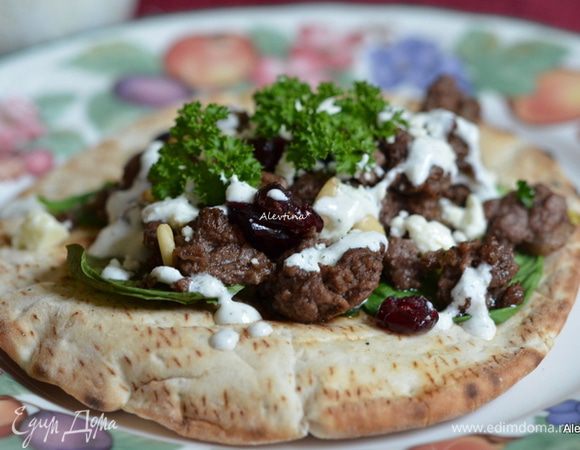 Подаем на лепешке с готовым фаршем, шпинат листьями, посыпаем очищенными кедровыми поджаренными орешками, вяленой клюквой, фетой, свежей зеленью. Поливаем соусом тцадзаки. Приятного аппетита.