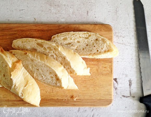 Чиабатту или багет нарезаем по диагонали. Кусочки не должны быть очень тонкими - около 2-2,5 см (тогда снаружи они будут хрустящие, а внутри мягкие).