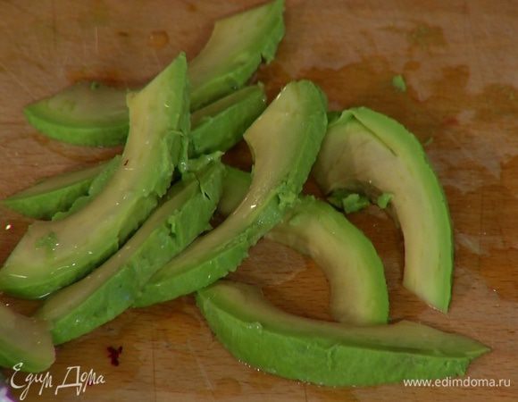 Авокадо почистить, нарезать тонкими полосками и сбрызнуть лимонным соком.