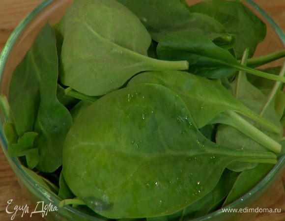 Листья шпината разложить на блюде, сбрызнуть оливковым маслом и оставшимся соком лимона, посолить и поперчить.