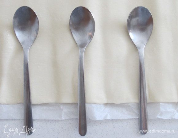 На слоеное тесто выкладываем чайные ложечки.