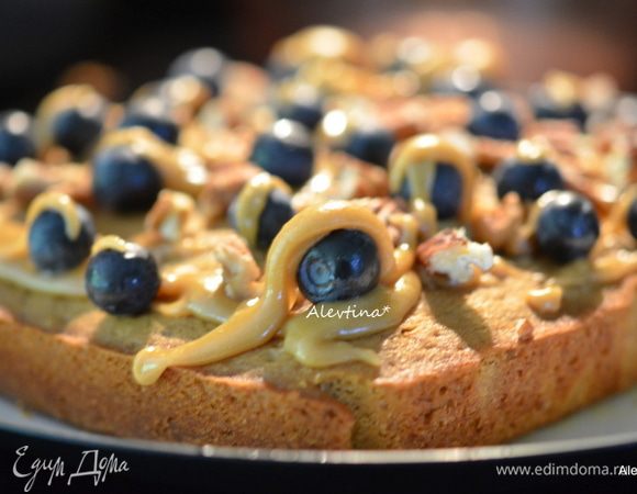 Украсить остывший кекс сверху ягодами остатком, очищенными орехами, крупно поломанными. Полить готовой глазурью. Разрезаем на 9 квадратов и подаем к столу. Или берем с собой на пикник в закрытом контейнере.