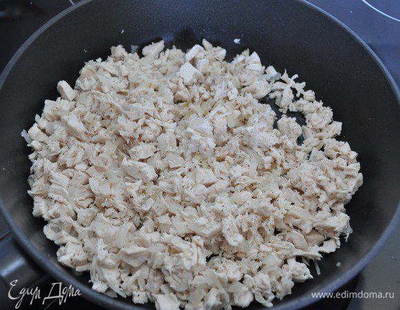 Куриное филе мелко порезать и добавить к луку, перемешать, поперчить, посолить с учётом солёности сыра. Вместе прогреть на среднем огне.
