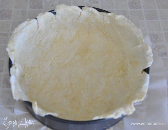 Включить разогреваться духовку до 180 градусов. Дно разъёмной формы застелить пергаментом, стенки смазать сливочным маслом. 
Охлажденное тесто разделить на две части: 2/3 и 1/3. Треть вернуть в холодильнике, а большую часть раскатать в круг, бОльший, чем форма. Тесто уложить в форму, формируя бортики.
