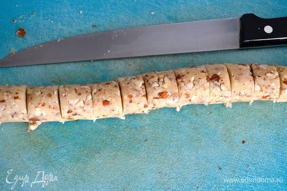 Раскатывая по столу полученную массу, сформируйте из нее колбаску и нарежьте её на 16 ровных частей (по количеству рогаликов).