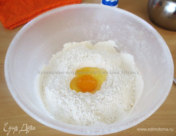 В муке сделать углубление, добавить яйцо.