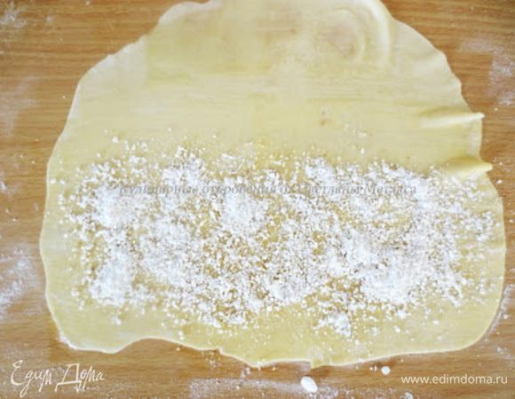 Заранее приготовить начинку. Для этого измельчить грецкие орехи и смешать их с сахарной пудрой, корицей и гвоздикой.Сахарной пудры должно быть 250 грамм. На половину листа равномерным слоем посыпать начинку