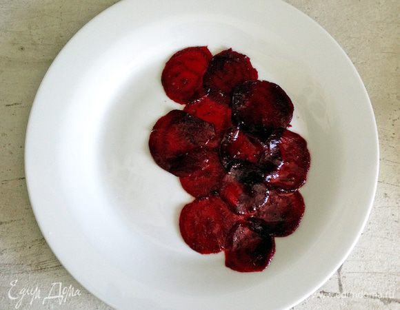 Аккуратно раскладываем ломтики свеклы на тарелку. Посыпаем руколой. Выкладываем крем из маскарпоне. Посыпаем кедровыми орешками, мелко нарезанным шнитт-луком и его соцветиями.