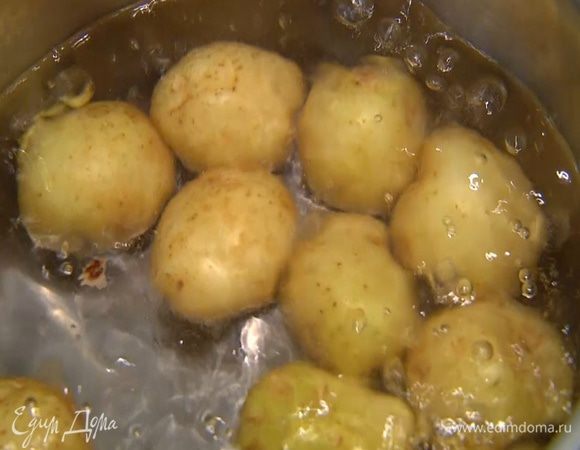 Картофель вымыть и, не очищая, отварить в кипящей соленой воде до готовности, затем воду слить.
