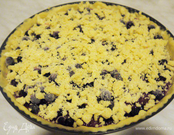 Раскатываем тесто, можно прямо в форме распределить тесто руками, обязательно сделать  бортик. Намазываем тесто джемом. Сверху кладем ягоды. В этот раз у меня замороженная черная смородина. Если ягода кислая можно увеличить количество сахара в посыпке. Посыпаем крошкой и выпекаем в разогретой духовке 45-50 мин при t 180С.