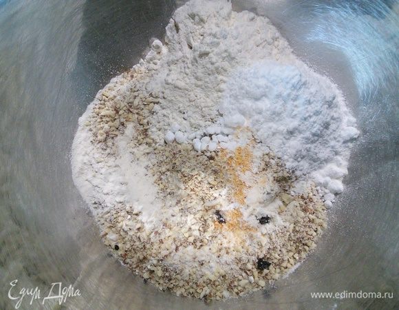 Смешайте в миске муку, миндальную крошку, цедру половины апельсина, шепотку соли и зёрнышки от половины стручка ванильной палочки. 