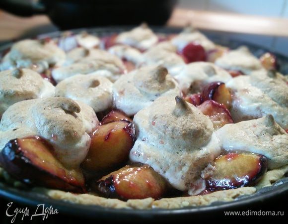 Поместите безе в кулинарный мешок. Выньте тарт из духовки. Температуру увеличьте до 220°С. Отсадите башенки безе в центр каждой сливы и запекайте ещё 7-8 минут. Безе должны подрумяниться. 