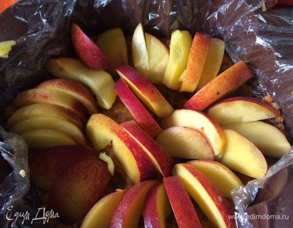 Выкладываем форму пленкой (или можно взять раздвижную, тогда пленка не нужна). На дне, делая бортики, конструируем слой "теста". На него декоративно раскладываем фрукты (здесь у меня персики). 