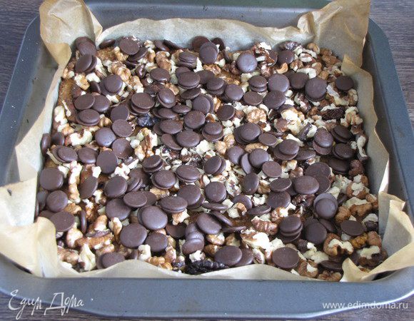 Шоколад порубить мелко, а орехи крупно. Я использовала готовые шоколадные кружочки. Посыпать готовый корж шоколадом и орехами.