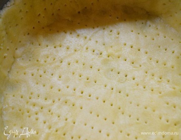 Достать тесто из холодильника. Выложить в форму, дно у которой выстелить пекарской бумагой... Сформировать высокие бортики и наколоть всю поверхность теста вилкой. Выпекать при Т 200 градусов 5 минут.