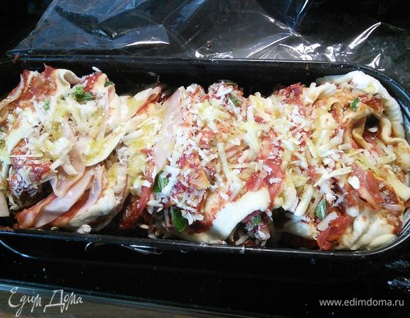 Натрусим немного сыра сверху и сбрызнем оливковым маслом. Запекаем в разогретой до 200°С духовке приблизительно 40 минут. Через 15 минут накройте бумагой для выпечки, чтобы пицца не подгорела. 