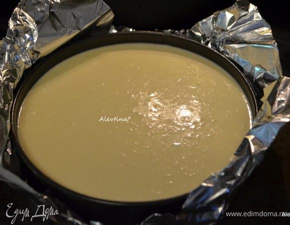 Укутать форму снизу и по краю фольгой , если у вас тонкая фольга берите два слоя. Поставить на противень. Перелить готовую начинку в форму с основой готовой. Долить на противень где форма горячей воды так чтоб хватило на все время запекания. Поставить в горячую духовку на 70-75 минут, не открывать в период приготовления.