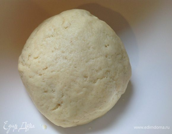 Замесить тесто. Оно должно быть "как мочка уха": эластичным, мягким и не очень крутым. Крупинки манной крупы будут ощущаться во время замеса, но это так и должно быть. Скатать тесто в шар, накрыть пленкой и оставить "отдыхать" на столе минут на 15-20. 