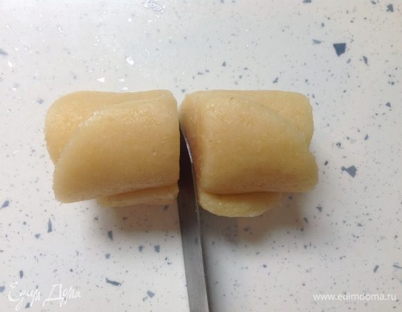 Разрезать (с помощью тонкого острого ножа) заготовку поперек на две части. Это удобно делать, как бы распиливая и одновременно слегка надавливая на тесто.