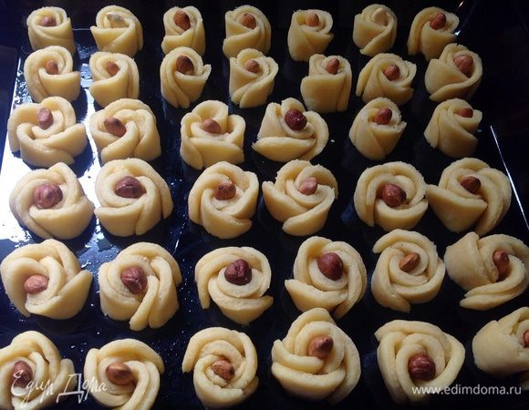 В середину каждого цветка поместить орех. Любой. Для крупных цветов удобно использовать фундук, для более мелких - арахис или абрикосовые косточки.
Выпекать в духовке при 170 градусах до зарумянивания. 