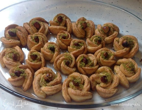 Оставить пропитаться. В первые полчаса с помощью ложки поливать сверху розочки сиропом (раза 2-3).
Через 1,5-2 часа печенья переложить в глубокое блюдо, заливая также щербетом. Розочки не будут оставаться сухими, так как на дне блюда находится щербет. 
Теперь можете подавать, посыпав измельченными в муку фисташками. 
** Десерт прекрасно хранится при комнатной температуре до 2-х дней. Не ставьте его в холодильник, а просто оставьте на столе в плоской стеклянной или фарфоровой посуде с сиропом на дне, накрыв плотно пищевой пленкой или крышкой.