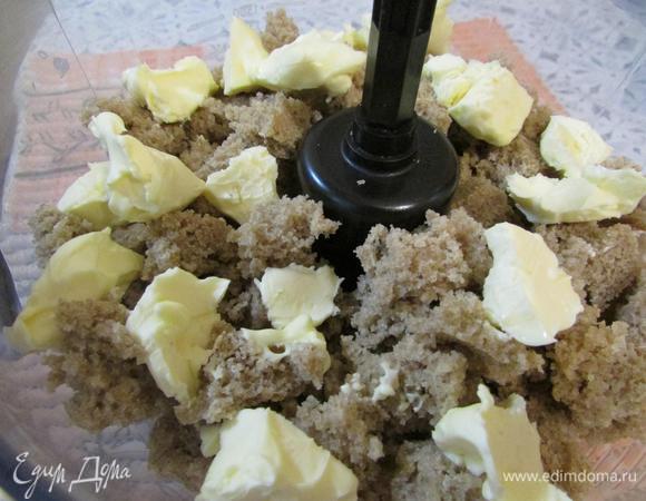 Хлеб поломать на маленькие кусочки и выложить в чашу блендера. Добавить сливочное масло и измельчить в крошку.
