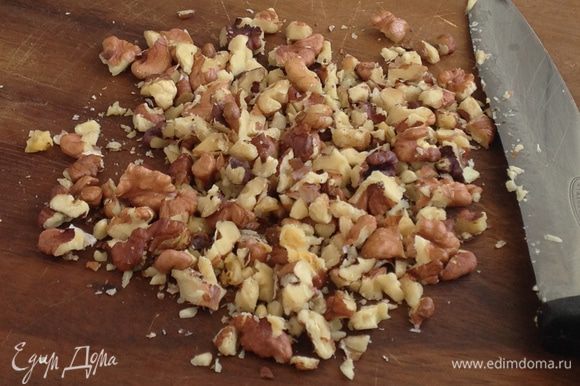 Нарежьте грецкие орехи на мелкие кусочки.