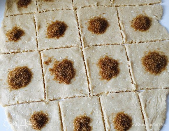Получившееся мягкое тесто раскалываем в пласт, разрезаем на квадратики. На каждый квадратик насыпаем сахар.