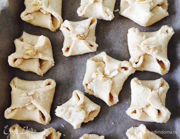 Складываем сегменты в конвертики, защипываем противоположные уголки. Замечу, что тесто у меня получилось не самое податливое - от того и вид немного пострадал. Но не вкуууус ;) Центр конвертиков украшаем миндальными лепестками, чтобы хоть как-то спасти ситуацию ;)