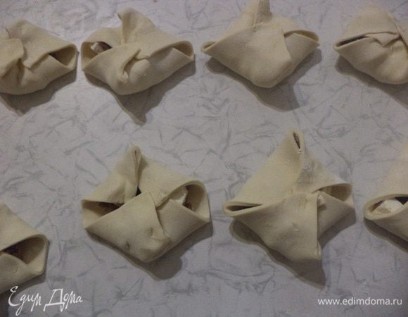 Концы теста поднять над начинкой и концы теста прижать друг к другу.
Конвертики смазать желтком, посыпать тмином. Выпекать при температуре 180 градусов 20-25 минут.